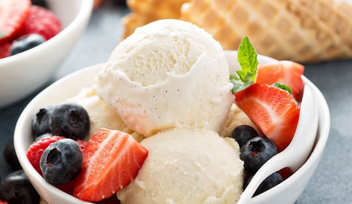 Vanilla ice cream with fruits around it in a bowl