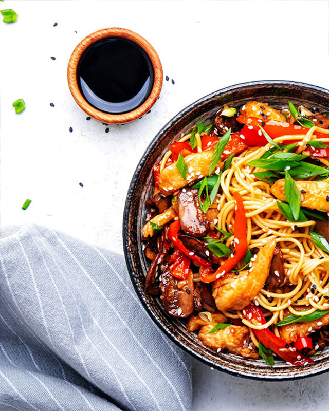 Stir fry on a plate with cup of soy sauce